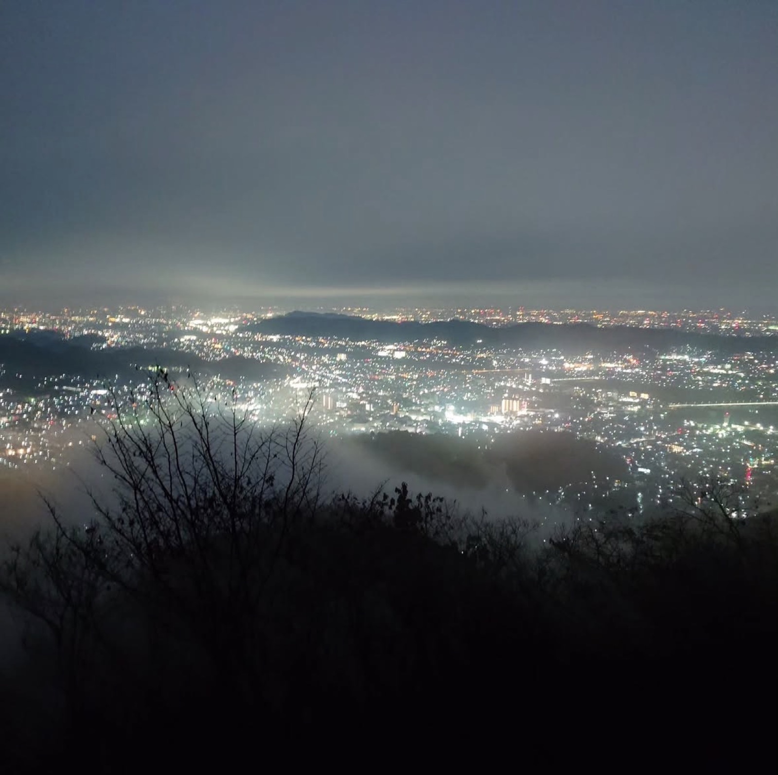 霧と夜景に包まれる山上からの眺め